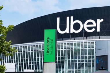 Uber Eats Music Hall Advertising logo on modern building facade, fusion of food tech and music in bustling urban setting, Berlin, Germany - August 16, 2024 clipart