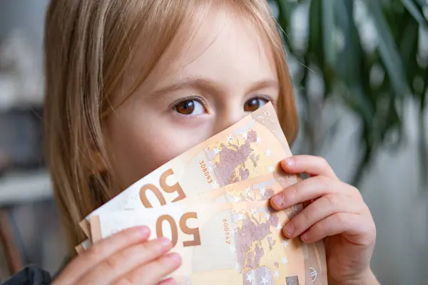 stock image female child, cheerful girl holds 50 euro banknotes close-up, imagination ignited power money, financial awareness, happy youngster