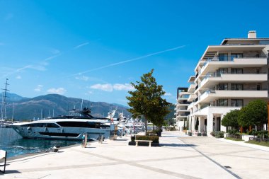 Karadağ limanı, çağdaş binalar, zarif konutlar, Tivat tatil beldesi ve yüksek yeşil dağlar tarafından desteklenen kıyı Modern Upscale marinasında sıra sıra dizilmiş lüks yatlar.