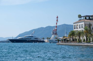 Karadağ limanı, çağdaş binalar, zarif konutlar, Tivat tatil beldesi ve yüksek yeşil dağlar tarafından desteklenen kıyı Modern Upscale marinasında sıra sıra dizilmiş lüks yatlar.