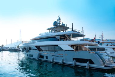 Beyaz lüks yat, marinaya yanaşmış motor, lüks sahil tatili, deniz deneyimi, okyanus yolculuğu, açık denizde özel yolculuk bekleyen yolcular.