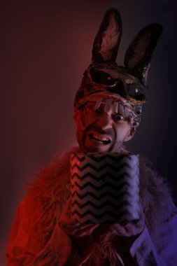 Ürkütücü tavşan adam, korkunç tavşan maskeli genç adam, hediyeli kutu, Cadılar Bayramı partisi konsepti, karanlık zombi maskesi, korku ve korku teması