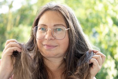 Olgun kadın kuru saçı, saç teftişinin, kişisel bakım rutininin ve öz-imaj, kırılgan uçlar, saç sağlığı ve bakım üzerindeki etkisinin incelenmesi.