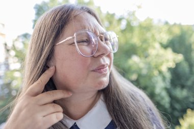 Mutsuz, olgun bir kadın, kulak ağrısı, kulak ağrısı, ekşitme, sağlık sorunları, tinitus semptomu, keskin ağrı sorunu, yardım arayışı.