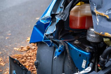 Buruşuk kaputu ve açıkta duran motoru olan ağır hasarlı bir araba, çarpışma sonrası, ön tarafında görünür hasar, kaza mahalli