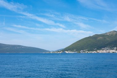 pikoresk deniz manzarası, Kotor Körfezi, Tivat Körfezi, Karadağ, arka planda dağlar, dalgalarda sallanan yalnız tekne, deniz yolculuğu, deniz yolculuğu ve yaz tatili