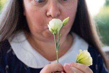 Yakın plan dişi burnu zevklerle ışıldar Eustoma 'nın kokusunu alır, baharın ve doğanın güzelliğini yakalar, aynı zamanda sezonsal alerjiler, duyusal deneyimler hakkında farkındalığı artırır.