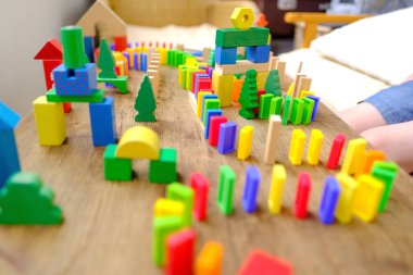 child building city with dominoes, understand the scientific principles behind the domino effect, Playful Learning Through Dominoes clipart