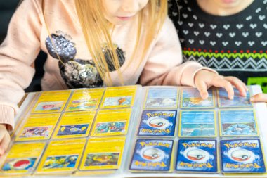 Genç Pokmon hayranları ticaret kartlarını paylaşıyor ve düzenliyor, neşeli ve neşeli bir atmosfer yaratıyor, nadir bulunan bulgular, çocukluk hobisi, Frankfurt - 18 Kasım 2024 