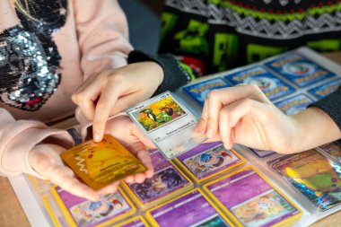 Genç Pokmon hayranları ticaret kartlarını paylaşıyor ve düzenliyor, neşeli ve neşeli bir atmosfer yaratıyor, nadir bulunan bulgular, çocukluk hobisi, Frankfurt - 18 Kasım 2024 