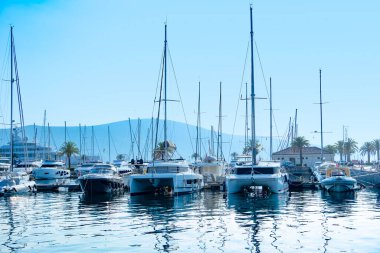 Luxurious yachts at Kotor Bay marina, Yachts docked at state-of-the-art marina in Porto Montenegro, with Montenegros iconic mountains in background, Tivat, Montenegro - August 6, 2024  clipart