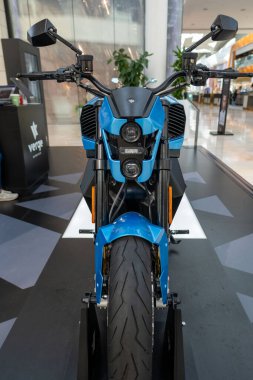 blue Verge TS Pro Elektro-Cruiser, electric motorcycle on display in retail showroom, emphasizing cutting-edge technology and futuristic appeal in London - September 16, 2024 clipart