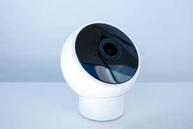 Beyaz arka plan, modern ev gözetlemesi ya da akıllı ev ayarlarına karşı gösterişli tasarımı olan küçük küresel güvenlik kamerası.
