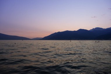 pikoresk gün batımı deniz manzarası, Kotor Körfezi, Tivat Körfezi, Karadağ, arka planda dağlar, dalgalarda sallanan yalnız tekne, deniz yolculuğu, deniz yolculuğu ve yaz tatili