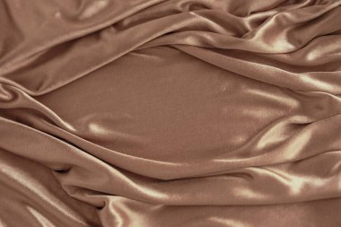 17-1230 Mocha Mousse, kumaş kumaşı sofistike, toprak rengi 2025. Moda tasarım endüstrisi için dalgalar ve kumaşlarla dolu lüks bir arka plan.