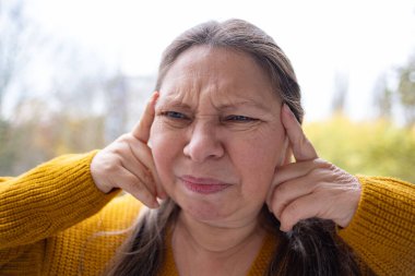 kederli ifadeli olgun bir kadın, migren nöbeti, şiddetli migren ağrısı, baş ağrısı, acı dolu bir ifade, migren krizi, yakın plan yüzü,