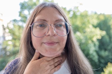 Yakın plan olgun kadın 55 yaşında, insan boynu, yerçekimsel ptosis, çift sarkık çene, Yaşlanma ve Yüz Görünümü, yaşla ilgili deri değişiklikleri, kozmetik yaşlanmayı önleme prosedürleri, cilt sıkılaştırma