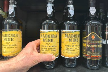 Birkaç şişe Madeira şarabı, ticari tarzda güçlendirilmiş şarap, eşsiz etiketler ve koyu renk güçlendirilmiş şarap, eşsiz tatlar.