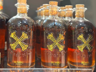 commercial-style shot of Bumbu rum, on store shelf, commercial-style shot fortified wine, unique premium quality and rich amber color of rum