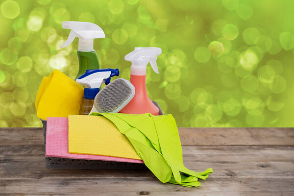 Корзина с чистящими средствами на размытом весеннем фоне, салфетки, моющие средства на столе, весенняя уборка дома, свежесть и жизнеспособность, организация и разборка дома