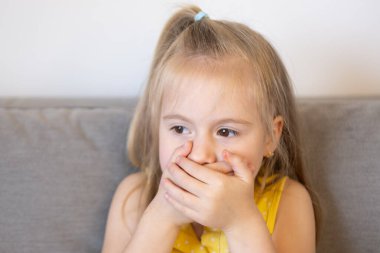 Çocuk, utangaç sarışın kız elleri ağızla kaplı, sır tutmak için mücadele ve öz disiplin, kontrol sorunları, sözlerine dikkat et.