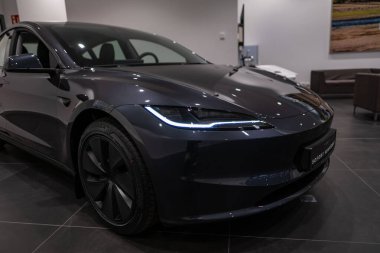 Parlak siyah Tesla Model 3, fütüristik farlar ve ikonik aerodinamik tasarım modern sergi salonunda sergileniyor, elektrik gücü Elon Musk şirketi Frankfurt 'ta - 25 Ocak 2025