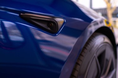 Yan kamera mavi araba yakın çekim, yenilikçi tasarım ve gelişmiş özellikler, sürücü güvenliği elektrikli araç, teknoloji harikası, yapay zeka sensörü