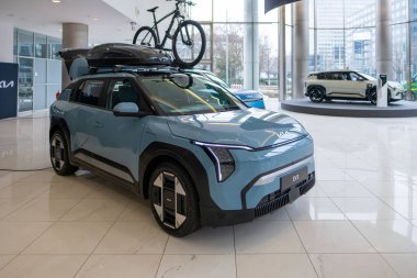 Yeni mavi Kia EV3 elektrikli SUV, modern sergi salonunda yeni nesil Güney Kore arabası, çevre dostu hareketlilik çözümleri, otomotiv endüstrisinde sıfır emisyon teknolojisi, Frankfurt - 3 Şubat 2025