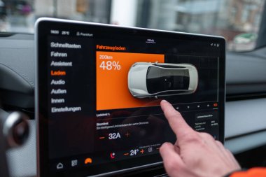 Sürücünün eli, Polestar 2 elektrikli arabadaki büyük, sezgisel dokunmatik ergonomik ekran ile etkileşime girer, sürücü merkezli kokpit ve gelişmiş teknoloji, Frankfurt - 3 Şubat 2025