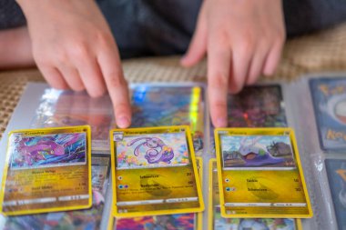 Pokmon kart albümüne bakan genç eller, çocuk koleksiyoncusu oyun kartları, heyecan ticareti ve koleksiyon, çocukluk koleksiyonu, Pokemon Fan Culture, Frankfurt - 18 Ekim, 2024 