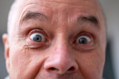 Şokta olan orta yaşlı bir adam, ağzı açık ve gözleri açık, saf duygu şaşkınlığı ve güvensizlik dolu beklenmedik haberleri yakalıyor, olgun bir adam şaşkınlık ve şokla tepki veriyor. Duygusal Portre