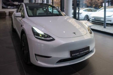 Beyaz Tesla Model Y elektrikli araba galeride, alternatif enerji geliştirme konsepti, elektrikli araba üretimi, elektrik santrali Elon Musk şirketi Frankfurt 'ta - 25 Ocak 2025
