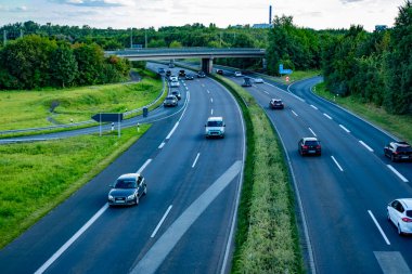 Modern çoklu şeritli otoyol, doğal manzara ufka kadar uzanıyor, yeşil ağaçlarla kaplı, aşağıda kuş bakışı hareketli trafik var, Frankfurt - 25 Ağustos 2024