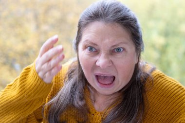 Şokta olan orta yaşlı bir kadın, ağzı açık ve gözleri açık, saf duygu sürprizi ve inançsız beklenmedik haberleri yakalıyor, olgun bir kadın şaşkınlık ve şokla tepki veriyor. Duygusal Portre