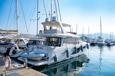 Kotor Körfezi marinasındaki lüks yatlar, Porto Karadağ 'daki son model marinaya yanaşmış, arkasında Montenegros ikonik dağları, Tivat, Karadağ - 6 Ağustos 2024 