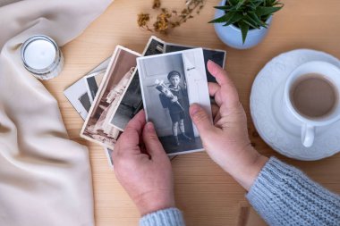 Eski Nostaljik fotoğraf albümü, ahşap masanın üzerinde boş bir resim alanı, hatıralar ve hatıralarla çevrili, konsept soy, hafıza ataları, aile bağları, duygusal atmosfer