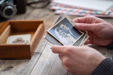 Yakın çekim erkek elleri siyah beyaz fotoğrafları sınıflandırır, nostalji ve geçmiş anıları hatırlatır, aile tarihini ve unutulmuş anları anar, aile arşivini hatırlar.