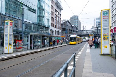 Sarı tramvay kullanma, insan tramvay istasyonu, şehir ulaşımı ve şehir ulaşımı, Avrupa, Berlin, Almanya 'da günlük sokak sahnesi - 24 Nisan 2024