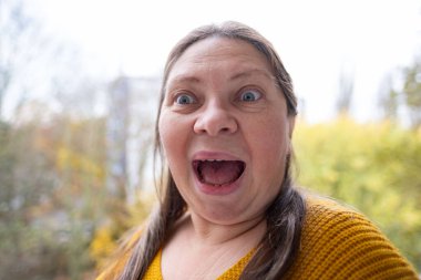 Şokta olan orta yaşlı bir kadın, ağzı açık ve gözleri açık, saf duygu sürprizi ve inançsız beklenmedik haberleri yakalıyor, olgun bir kadın şaşkınlık ve şokla tepki veriyor. Duygusal Portre