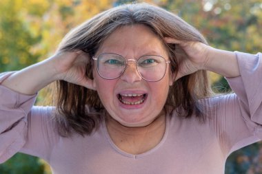 Yakın plan orta yaşlı kadın şok olmuş ve şaşkın bir ifadeyle, geniş gözler ve açık bir ağızla derin bir şaşkınlık, duygusal dramatik bir portre, şaşkınlık ve huşu sergiliyor.