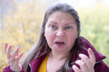 Öfkeli olgun kadınlar, öfke, öfke ve hüsran dolu bakışlar, kadın yüzünde tehditkar ifade, yoğun duygu, canlı sonbahar ayarı.