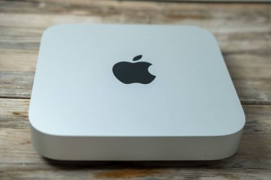 Mac Mini M1 bilgisayarı erkeklerin elinde, Apple logosu, teknolojik taşınabilirlik, uzaktan kumandalı ev ortamında çalışıyor, uzaktan kumandalı iş, vites küçülten yaşam tarzı, Frankfurt - 4 Şubat 2025