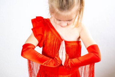 Çekici 5 yaşındaki sarışın kız, canlı kırmızı elbiseli genç dansçı Latin dans figürleri sergiliyor. Yetenek, enerji, ritim, özgüven, kendini ifade etme ve sanata erken adanmışlık, dans dersleri veriyor.