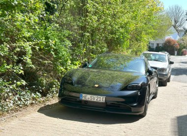 Siyah modern elektrikli araç, şehir ortamında Porsche Taycan, Avrupa caddesinde park edilmiş ev arabası, otomotiv endüstrisi, sürüş geleceği, Frankfurt - 11 Nisan 2025