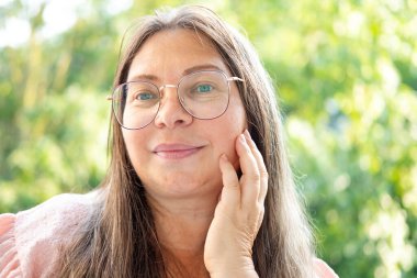 Kapalı yüz, olgun kadın 55 yaşında, insan boynu, çift sarkık çene, yaşlanma ve yüz görünümü, yaşla ilgili deri değişiklikleri, kozmetik yaşlanmayı önleme prosedürleri, cilt sıkılaştırma