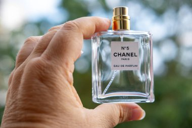 Boş Chanel Hayır. Kadın elinde 5 parfüm şişesi, zarafet ve nostalji, geçici güzellik, lüks ve parfümün ebedi cazibesi, Frankfurt - 4 Ekim, 2024 