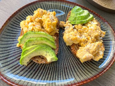 Avokado tostlu kahvaltı, çırpılmış yumurta, meyve salatası, sağlıklı yemek, kafe ziyafeti, brunch zamanı, besleyici ve lezzetli yemekler için taze malzemeler, sağlıklı ve renkli tabaklar.