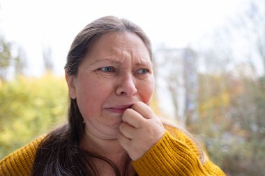 Mutsuz, olgun bir kadın, kulak ağrısı, kulak ağrısı, ekşitme, sağlık sorunları, tinitus semptomu, keskin ağrı sorunu, yardım arayışı. 