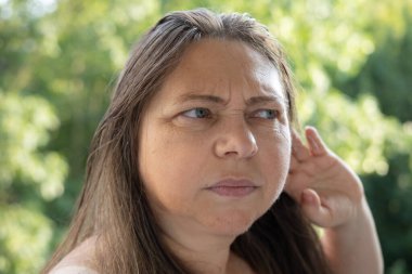 Mutsuz, olgun bir kadın, kulak ağrısı, kulak ağrısı, ekşitme, sağlık sorunları, tinitus semptomu, keskin ağrı sorunu, yardım arayışı. 