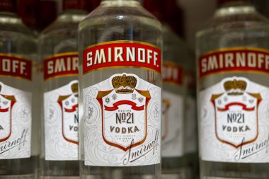Rafta Smirnoff marka votka şişeleri, gösterişli ikonik markalar, yüksek kaliteli alkollü içecekler, gümrüksüz satış, reklam ürünü fotoğrafçılığı, ticari tarz çekim, Londra - 16 Kasım 2024